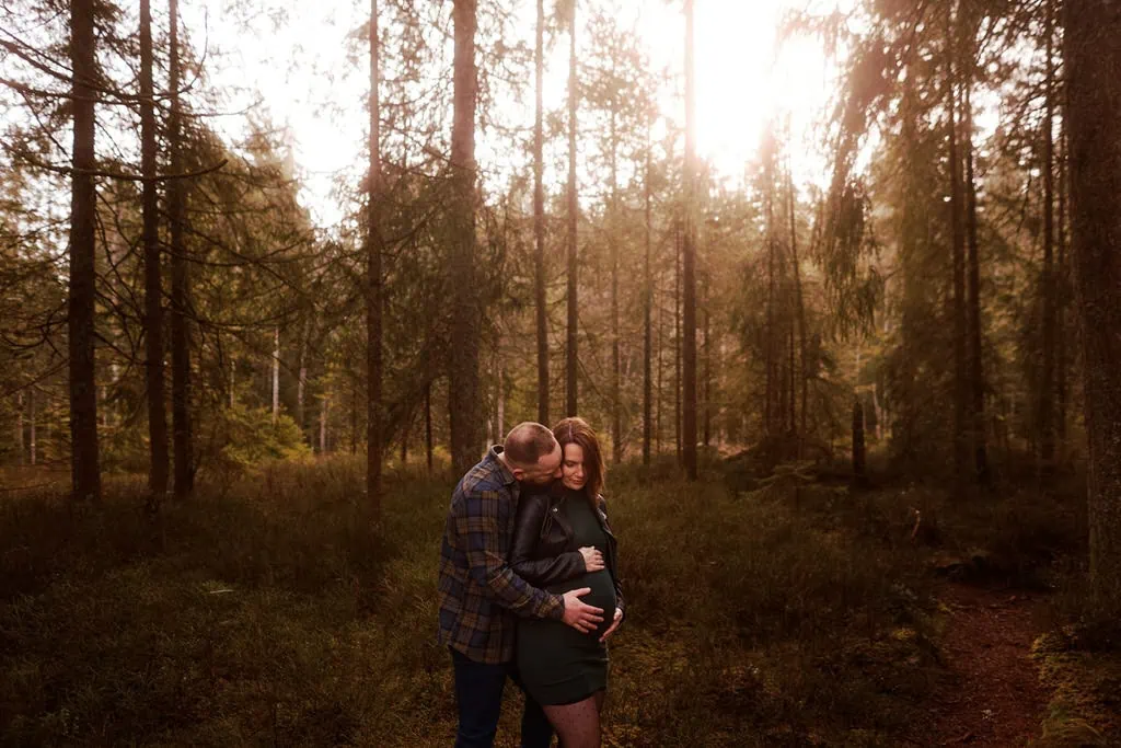 Couple dans la forêt, l'homme touche le ventre.
