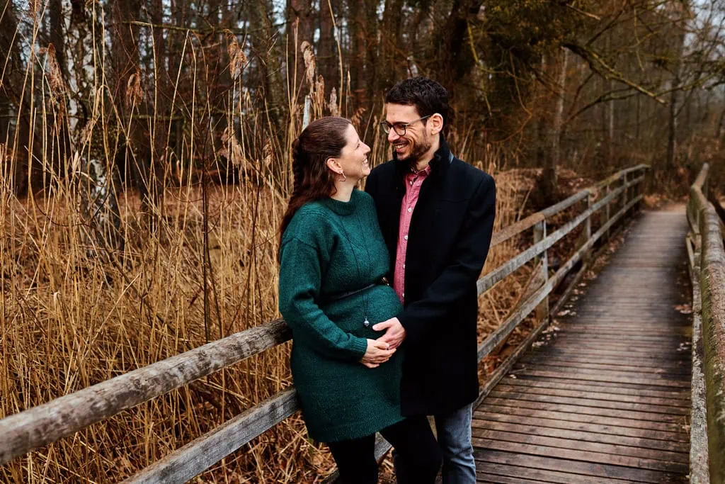 Couple souriant sur un pont en bois.