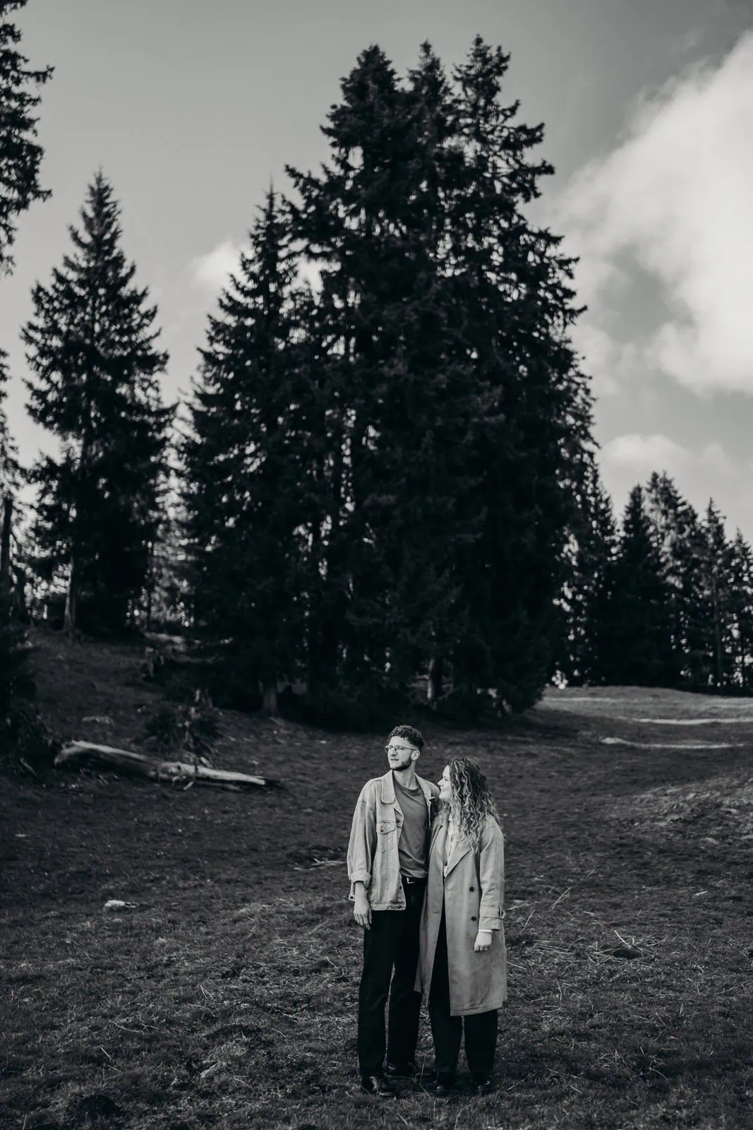 Couple regarde l'horizon devant les arbres.