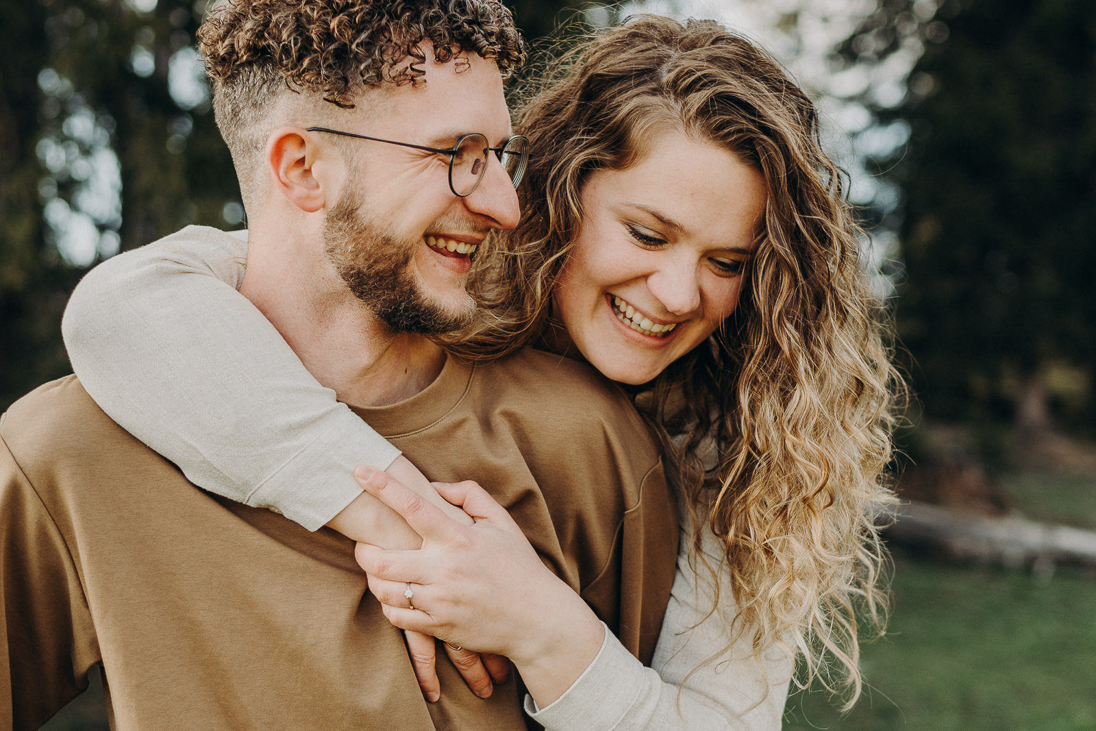 Couple souriant en plein air, étreinte chaleureuse.