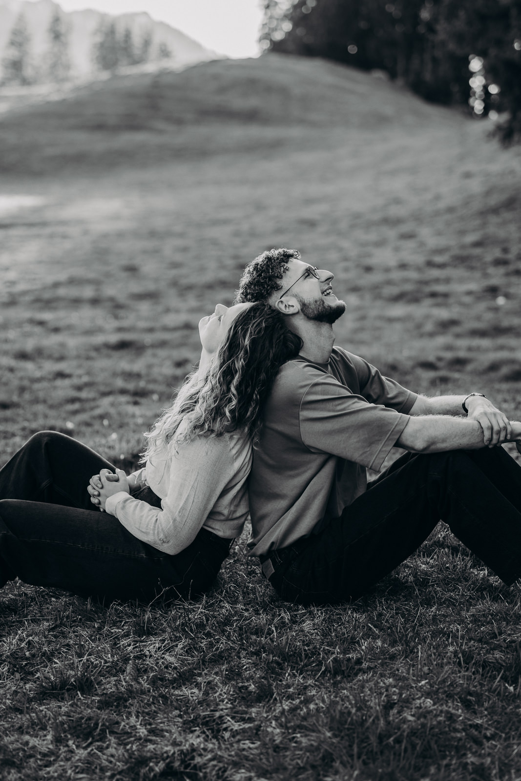 Couple assis dos à dos dans un pré