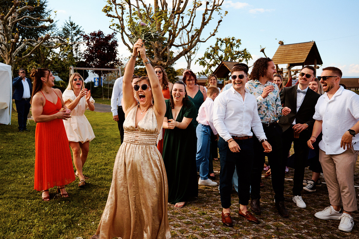 Femme heureuse tenant un bouquet, foule en arrière-plan.