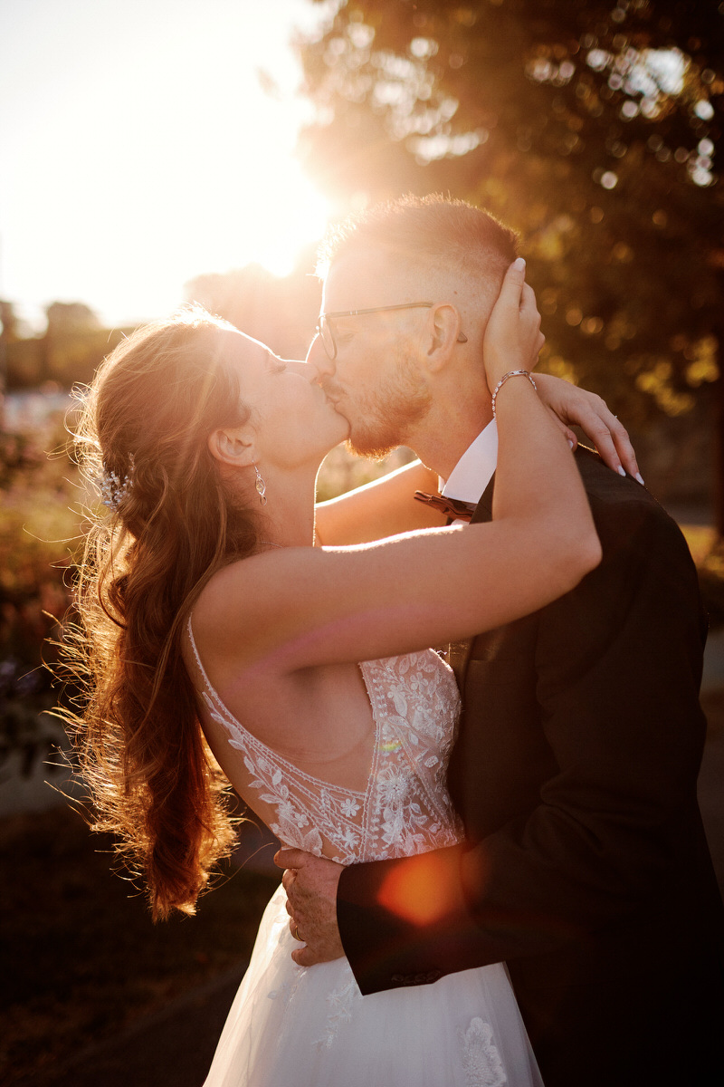 Couple s'embrassant au coucher du soleil.
