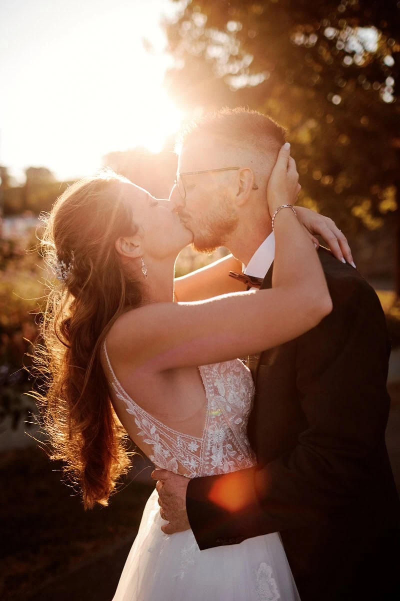 Couple s'embrassant au coucher du soleil.