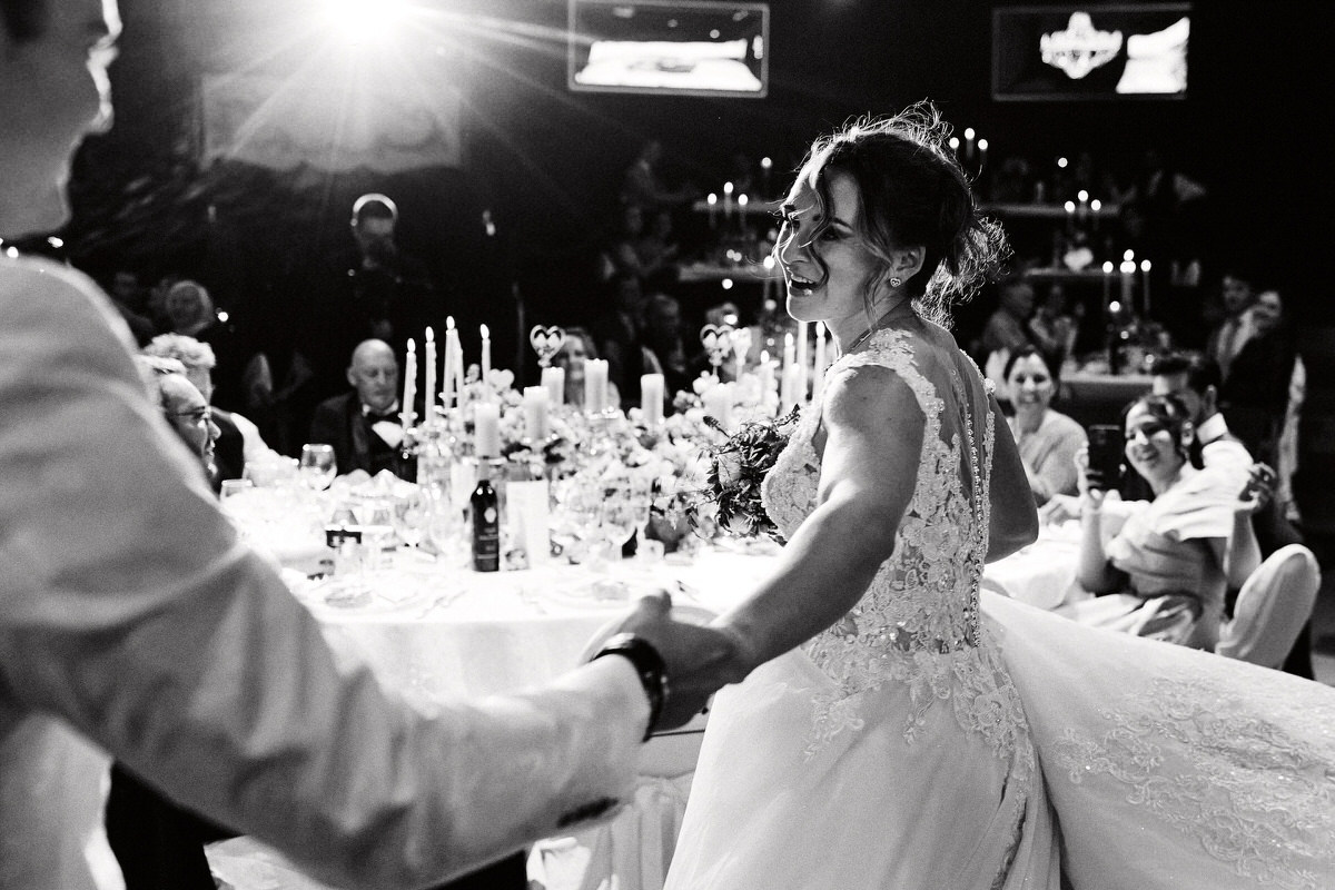 Mariée dansant au mariage avec invités souriants.