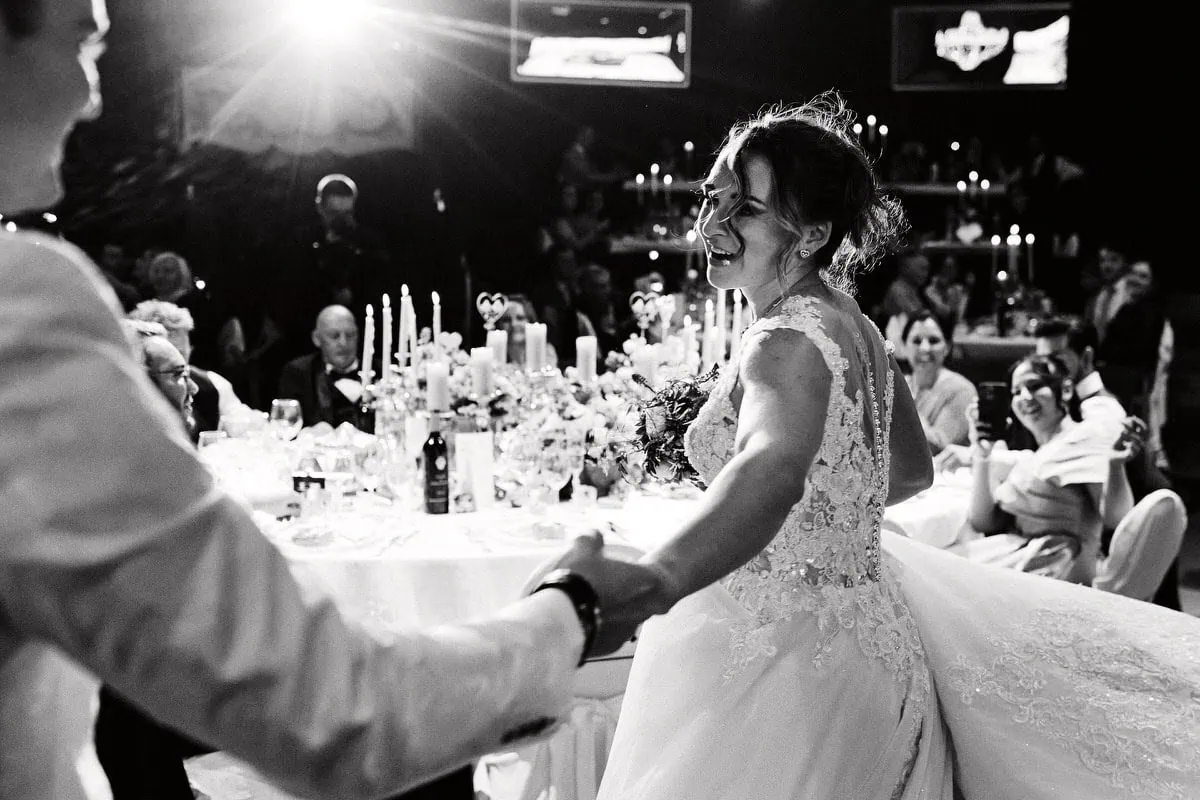 Mariée dansant au mariage avec invités souriants.