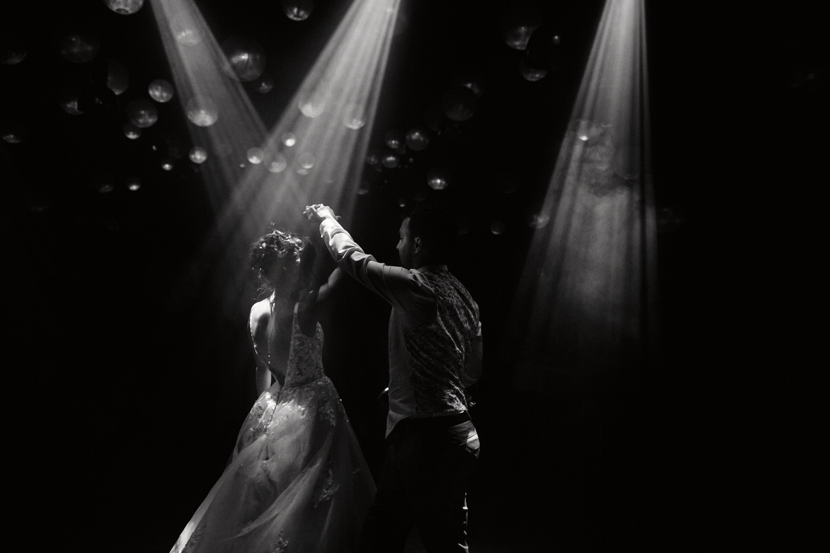 Couple dansant sous les lumières, ambiance romantique.