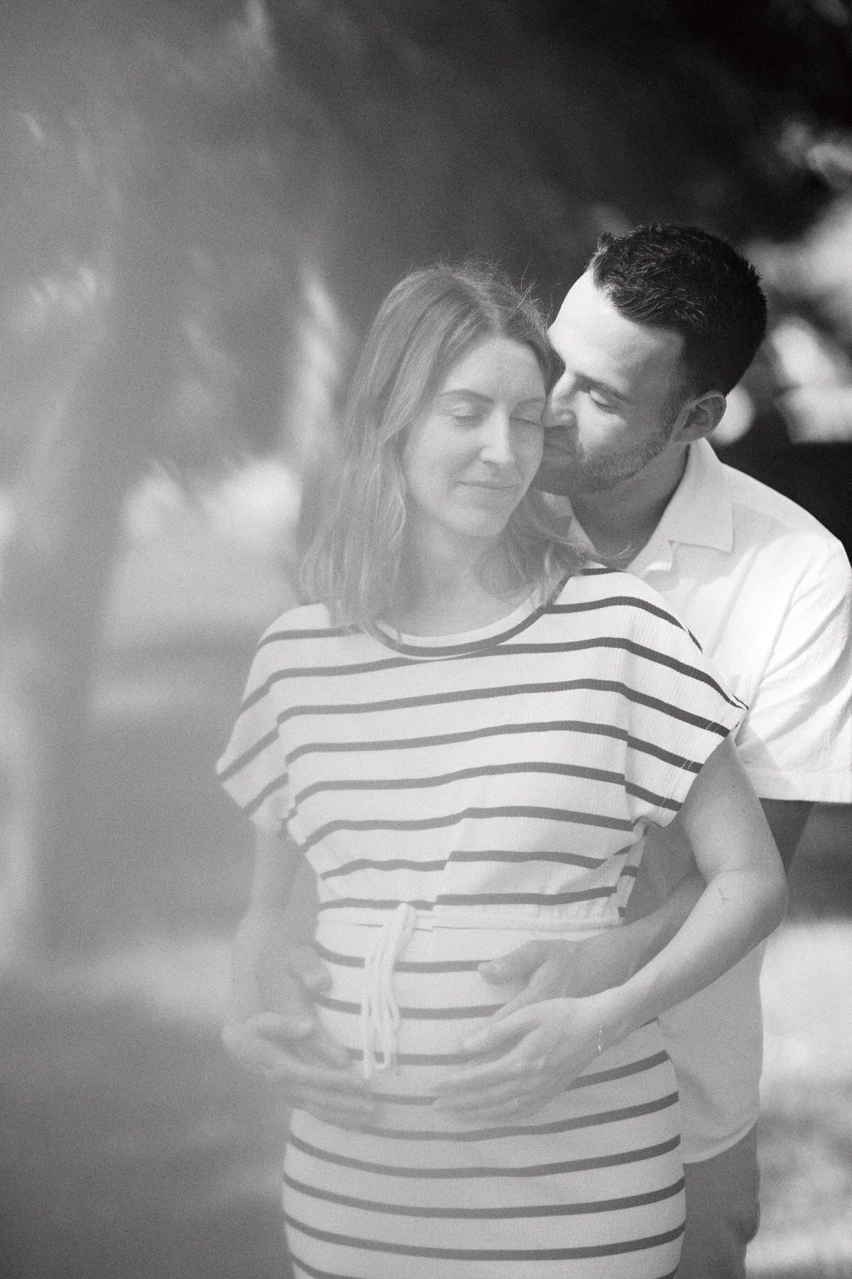 Couple embrassant avec tendresse en noir et blanc.