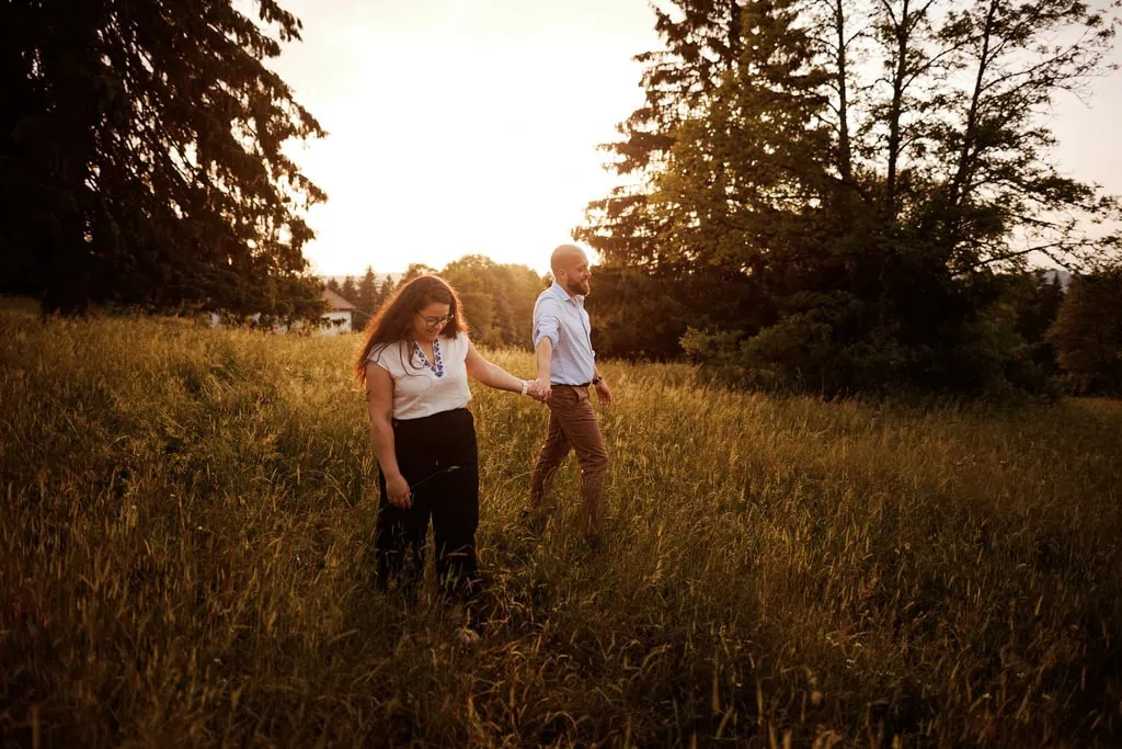 Couple marchant main dans la main au coucher du Soleil