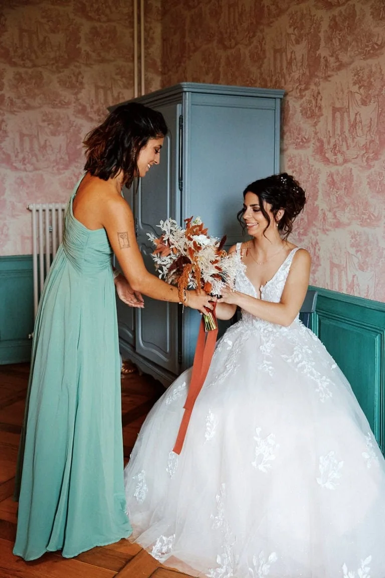 Mariée souriante recevant un bouquet.