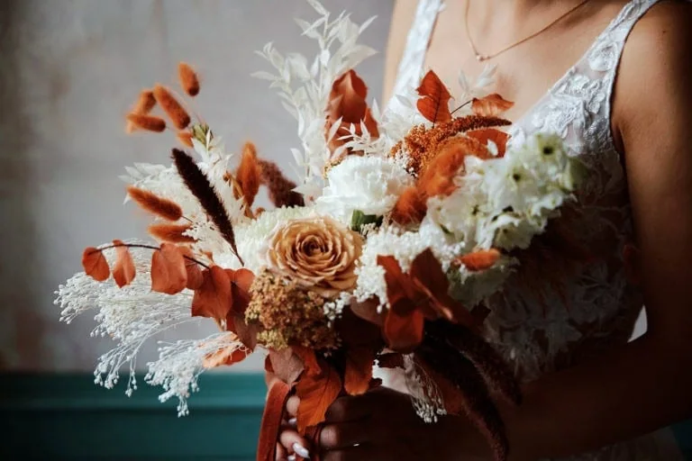 Bouquet de fleurs oranges et blanches, robe blanche.