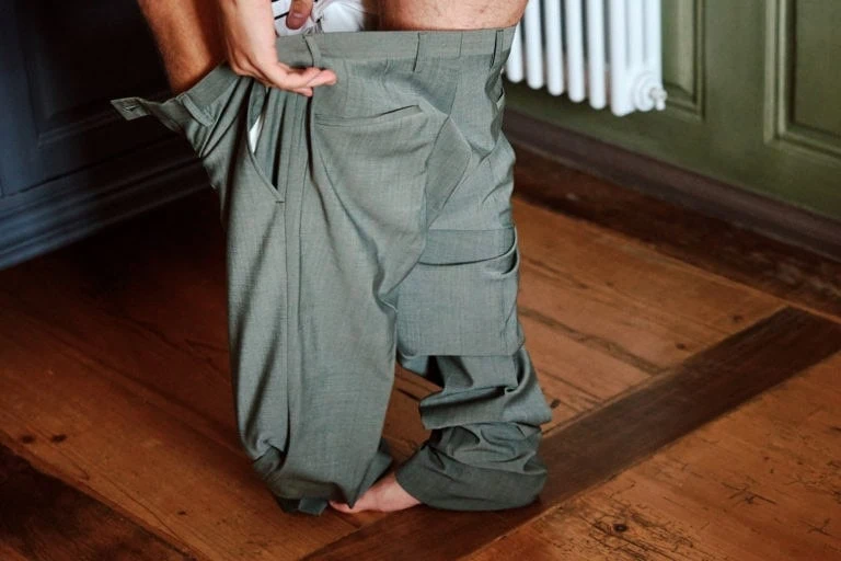 Personne mettant un pantalon vert-olive.