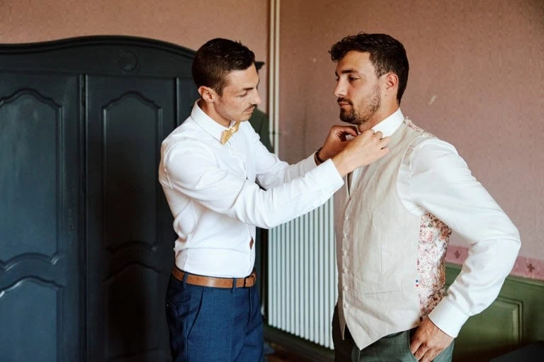 Deux hommes ajustant leur tenue formelle.