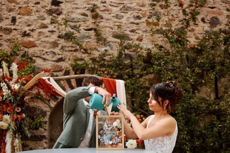 Couple arrosant plante lors d'une cérémonie de mariage.