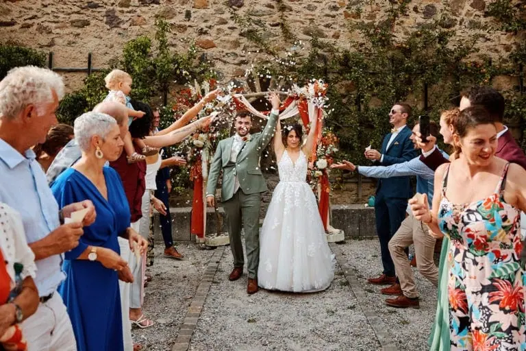 Mariée et marié sortant sous des pétales.