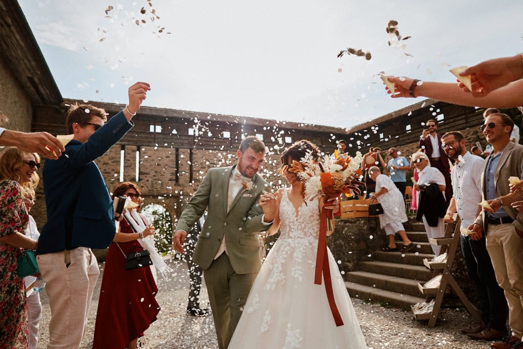 Couple marié fête avec invités et confettis.