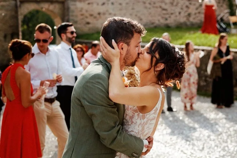 Couple s'embrassant lors de leur mariage en extérieur.