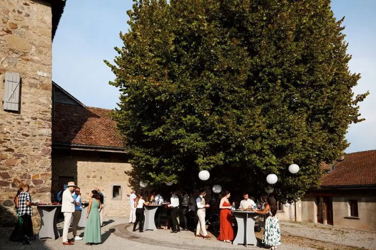 Groupe de personnes discutant sous un arbre.