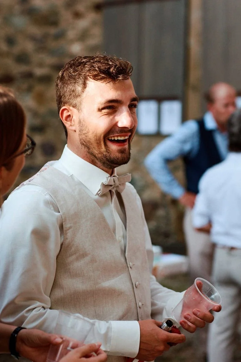 Homme souriant avec verre, événement social.