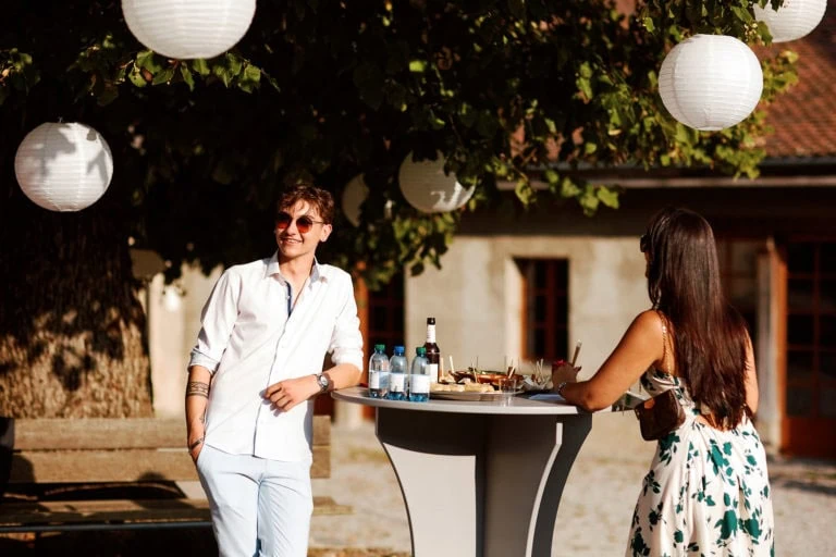 Personnes discutant à une réception en plein air.