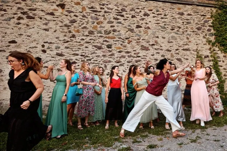 Femmes attrapant bouquet mariage, ambiance joyeuse.