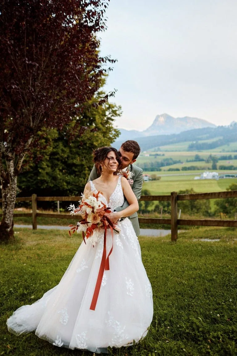 Couple de mariés, jardin, montagne en arrière-plan.
