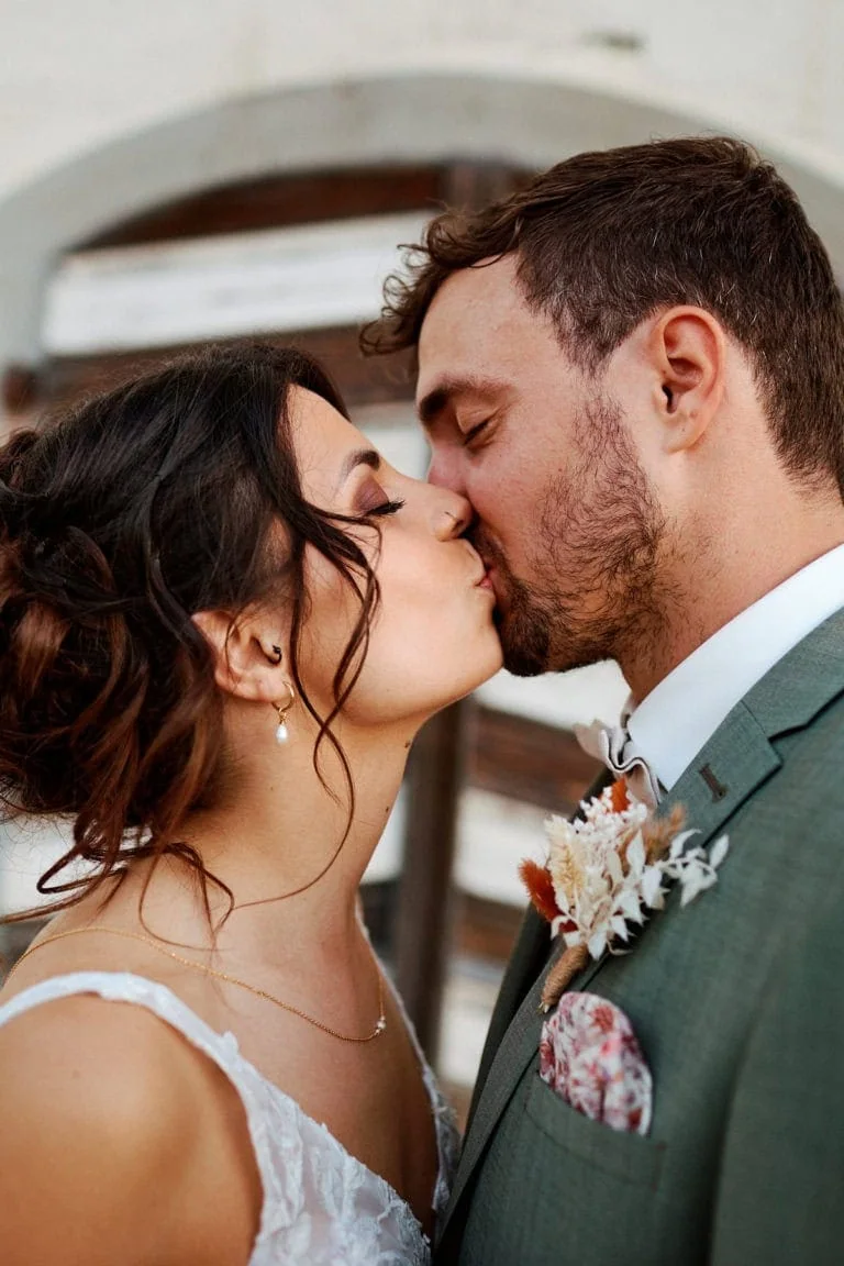 Couple s'embrassant le jour de leur mariage.