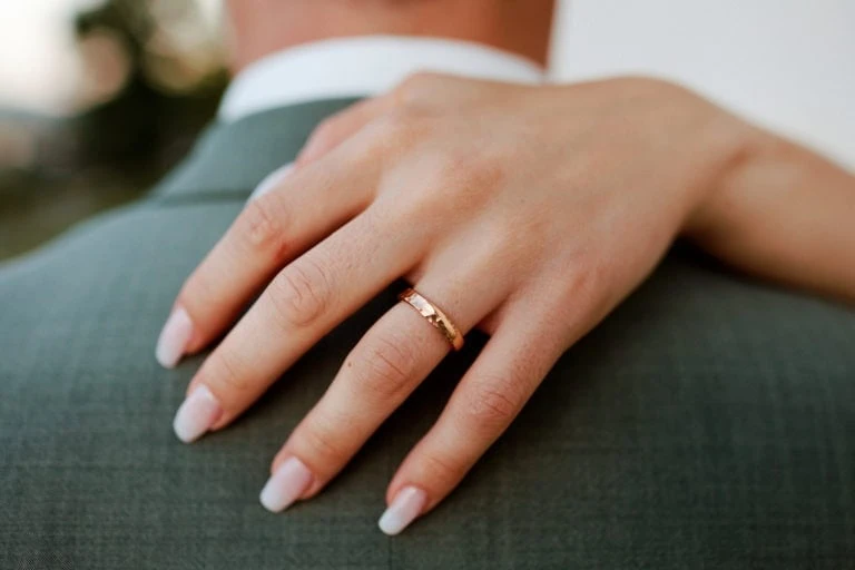 Main avec bague sur épaule en costume.