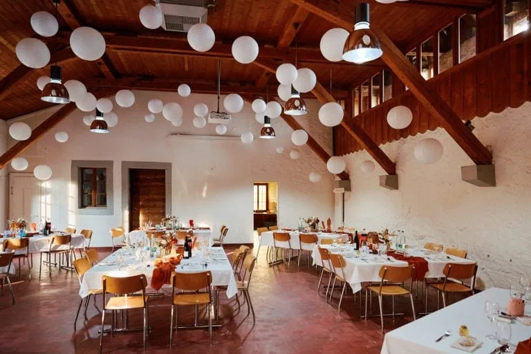 Salle de réception avec décorations suspendues blanches.