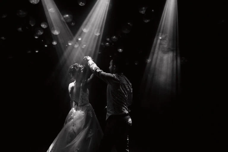 Couple dansant sur scène avec lumières.