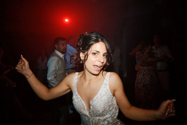 Femme dansante avec des invités derrière elle.