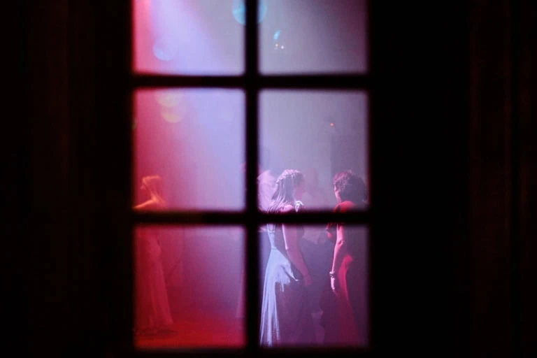 Personnes dansant éclairées par des lumières colorées.