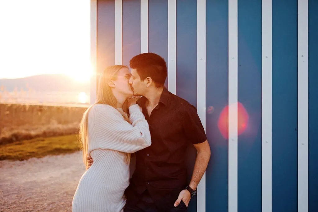 Couple s'embrassant au coucher du soleil.