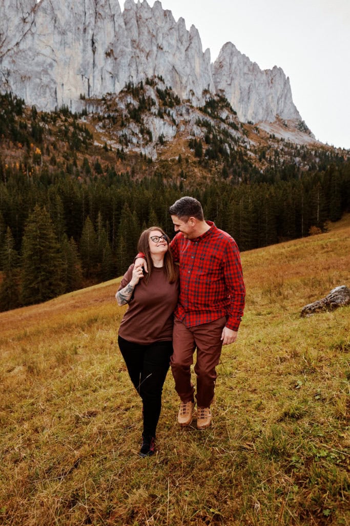 Couple marchant dans un paysage montagneux.