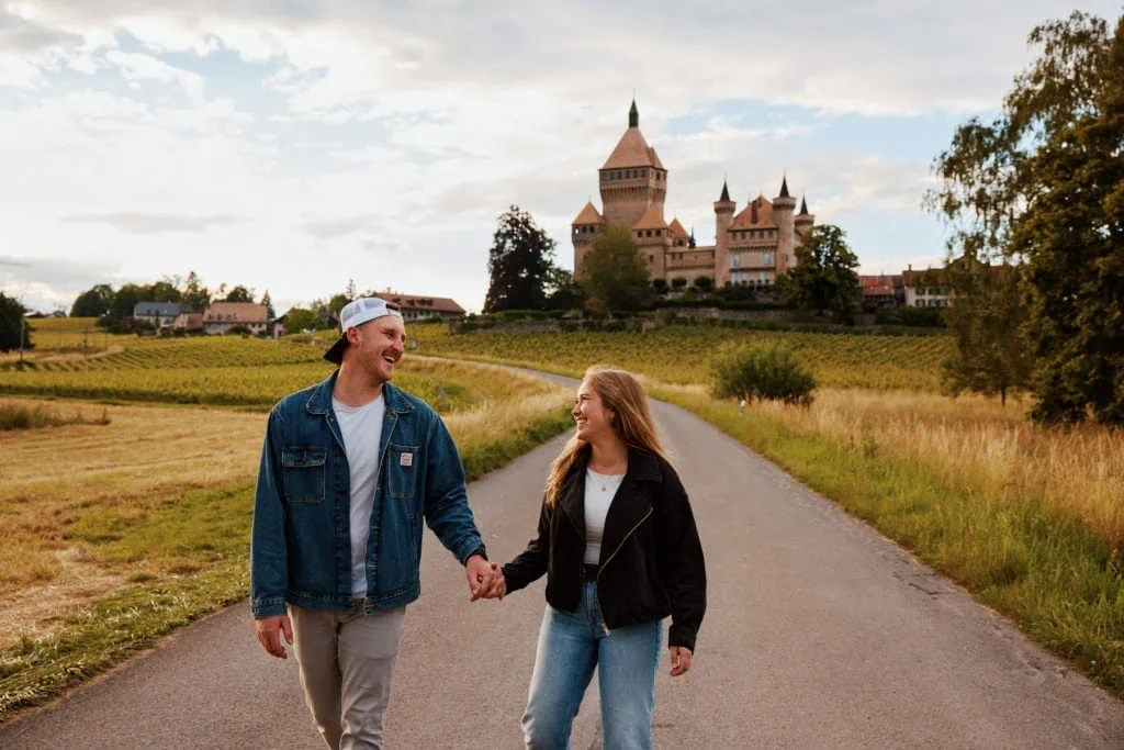 Couple marchant vers un château en campagne.