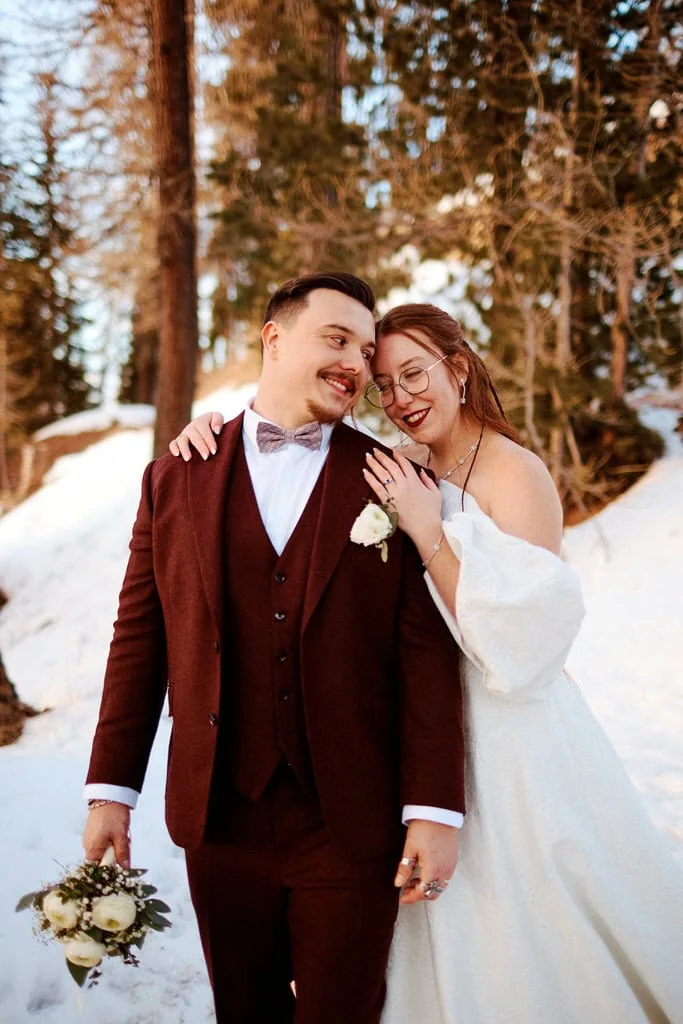 Couple marié dans la neige, heureux et souriants.
