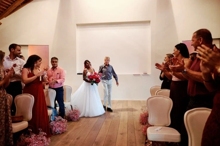 Mariée entrée, invités applaudissant dans la salle.