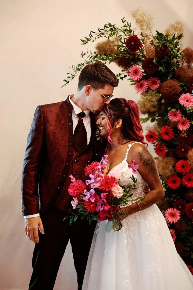 Couple marié avec bouquet de fleurs coloré.