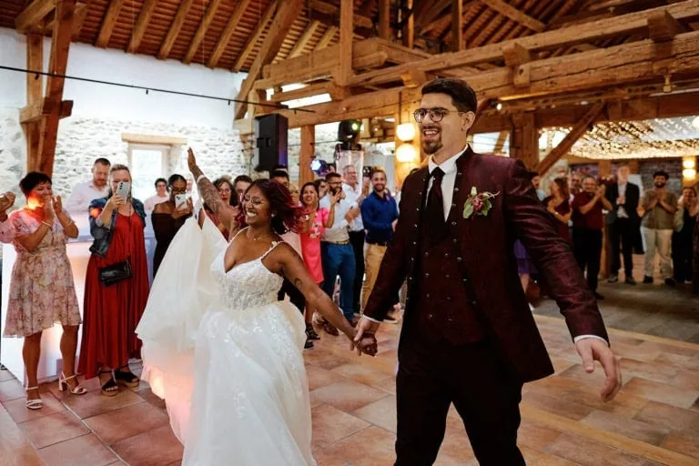 Couple marié souriant tenant la main en dansant.