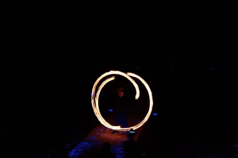 Artiste manipulant des cercles de feu la nuit.