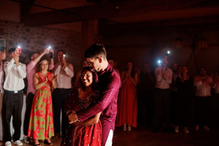 Couple dansant entouré d'invités applaudissant.