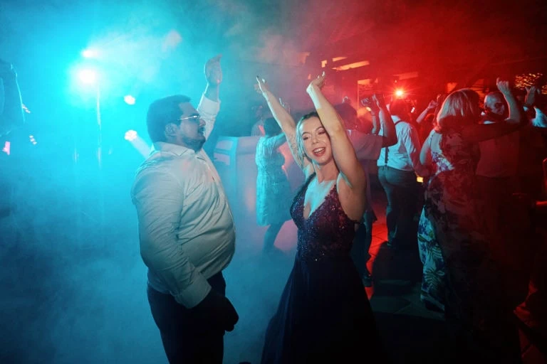 Personnes dansent sous lumières colorées en soirée.