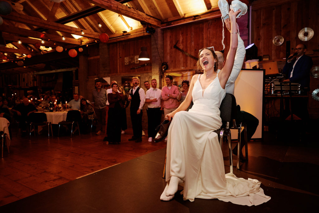 Animation de mariage en soirée, la mariée lève des chaussures pendant le jeu des chaussures.