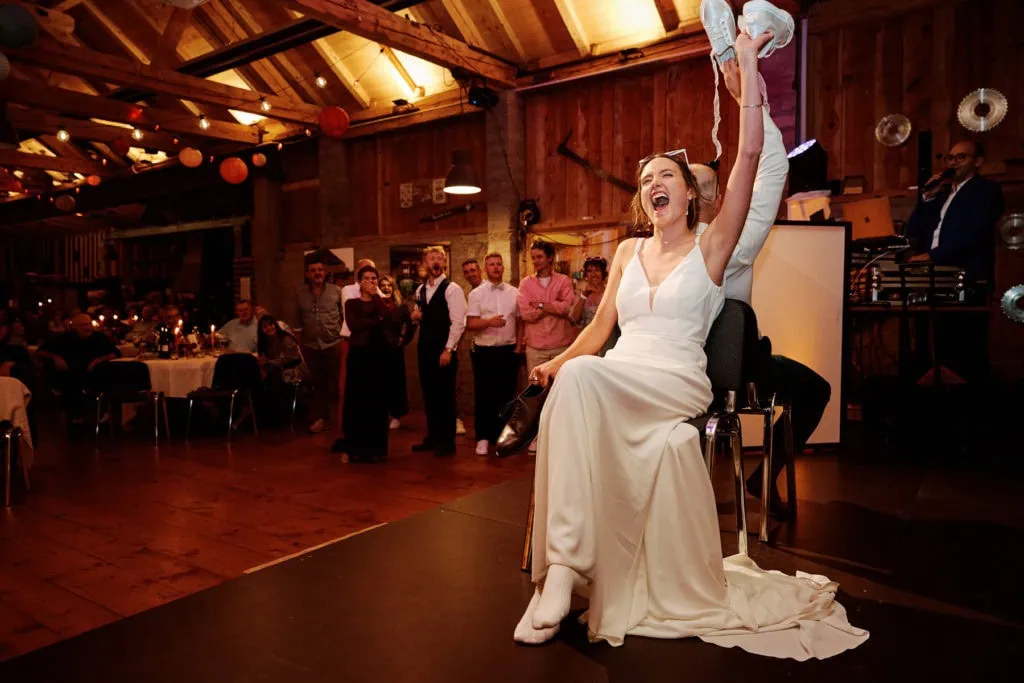 Animation de mariage en soirée, la mariée lève des chaussures pendant le jeu des chaussures.