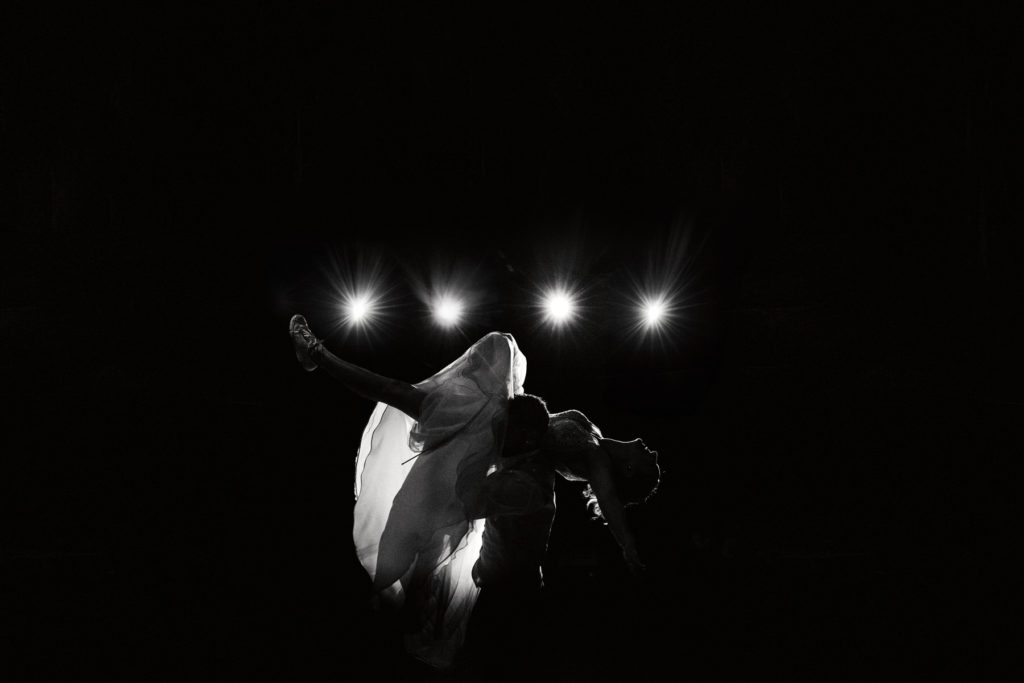 Silhouette des mariés pendant la danse, éclairée par des spots en arrière-plan