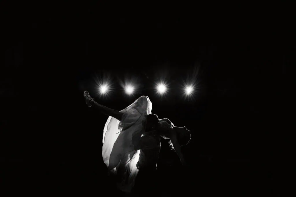 Silhouette des mariés pendant la danse, éclairée par des spots en arrière-plan