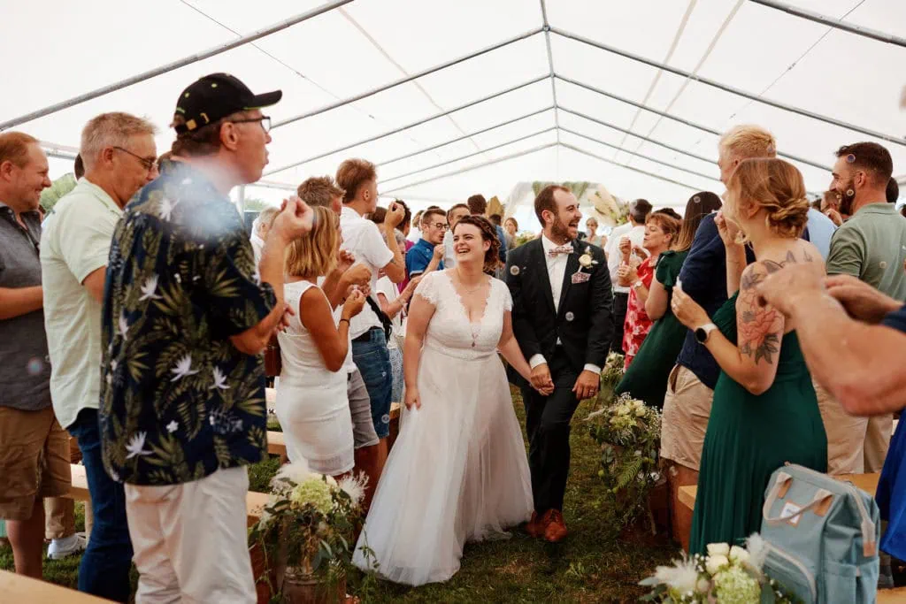 Cérémonie de mariage sous chapiteau avec invités.