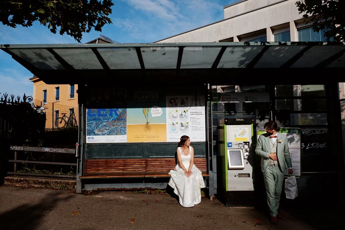 Couple en tenue de mariage à un arrêt de bus