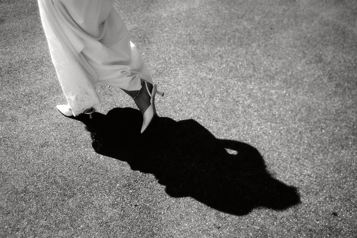 Femme en robe blanche marchant sur la route