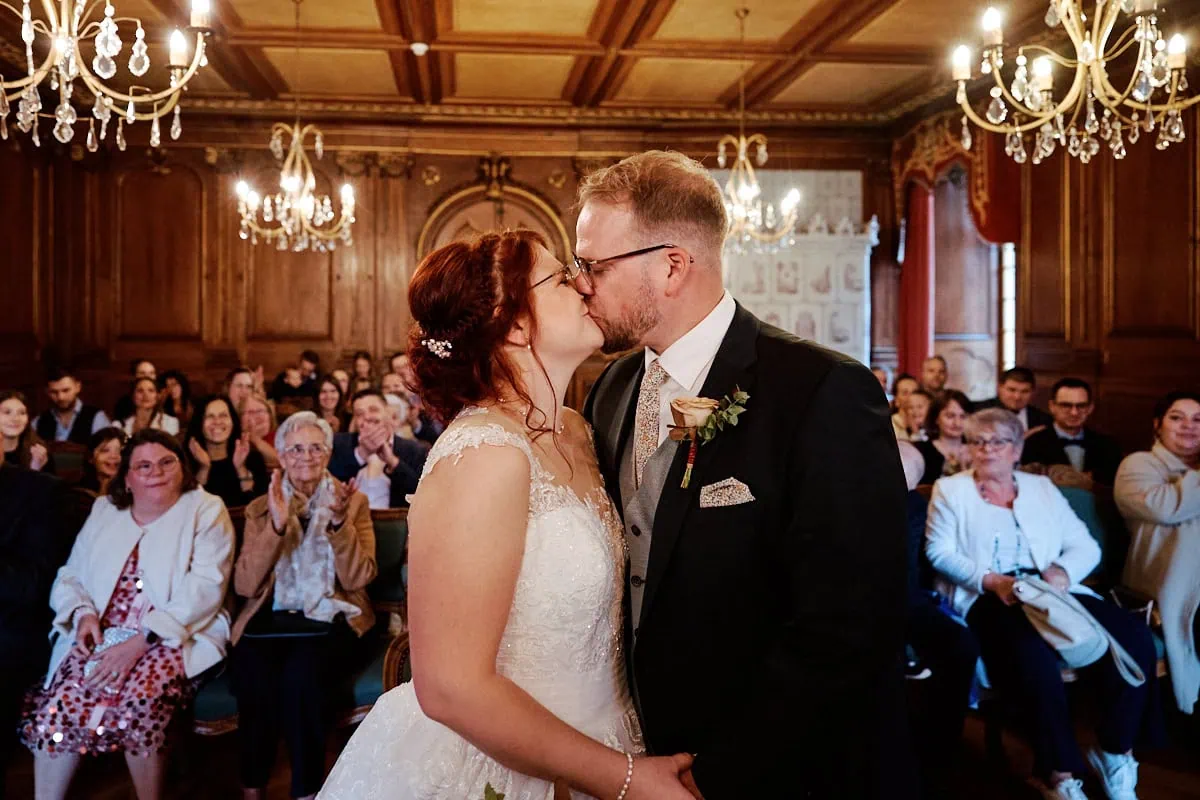 Mariés s’embrassant devant leurs invités à la mairie.